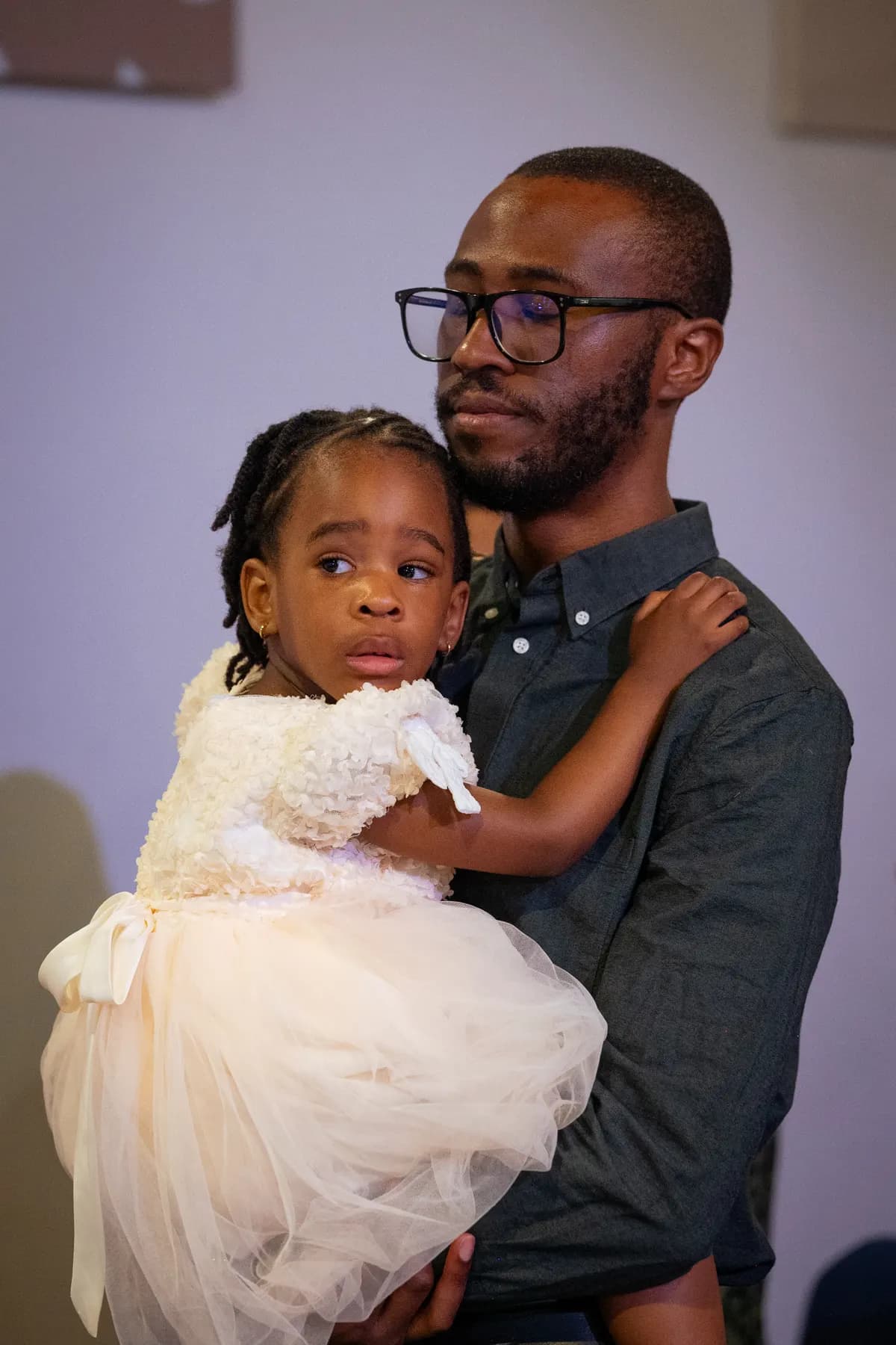 A father holding his young daughter at church